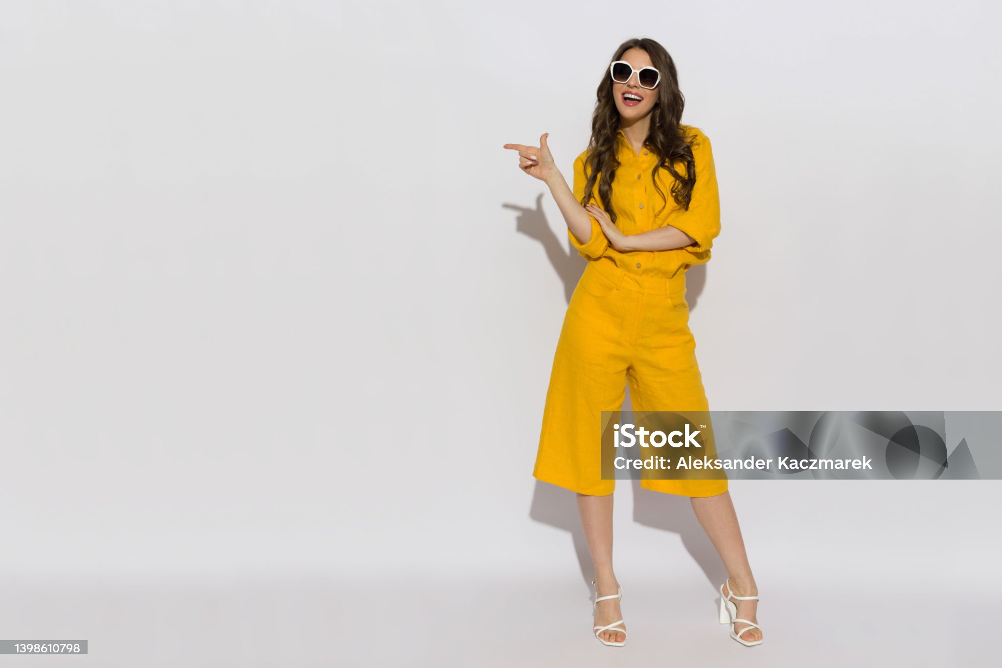 Model in yellow linen two-piece set on white studio background